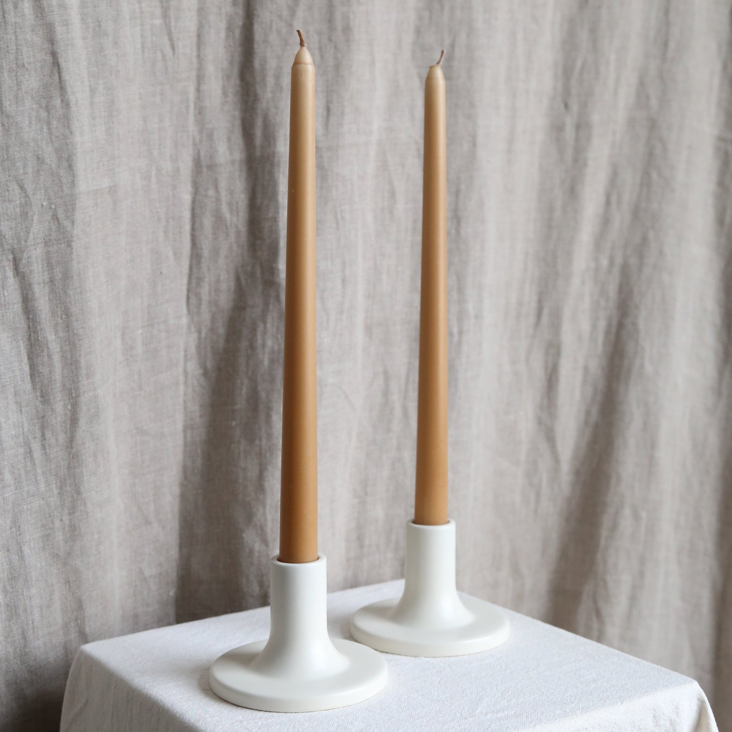 Pair of caramel taper candles in white holders available at Rook & Rose.