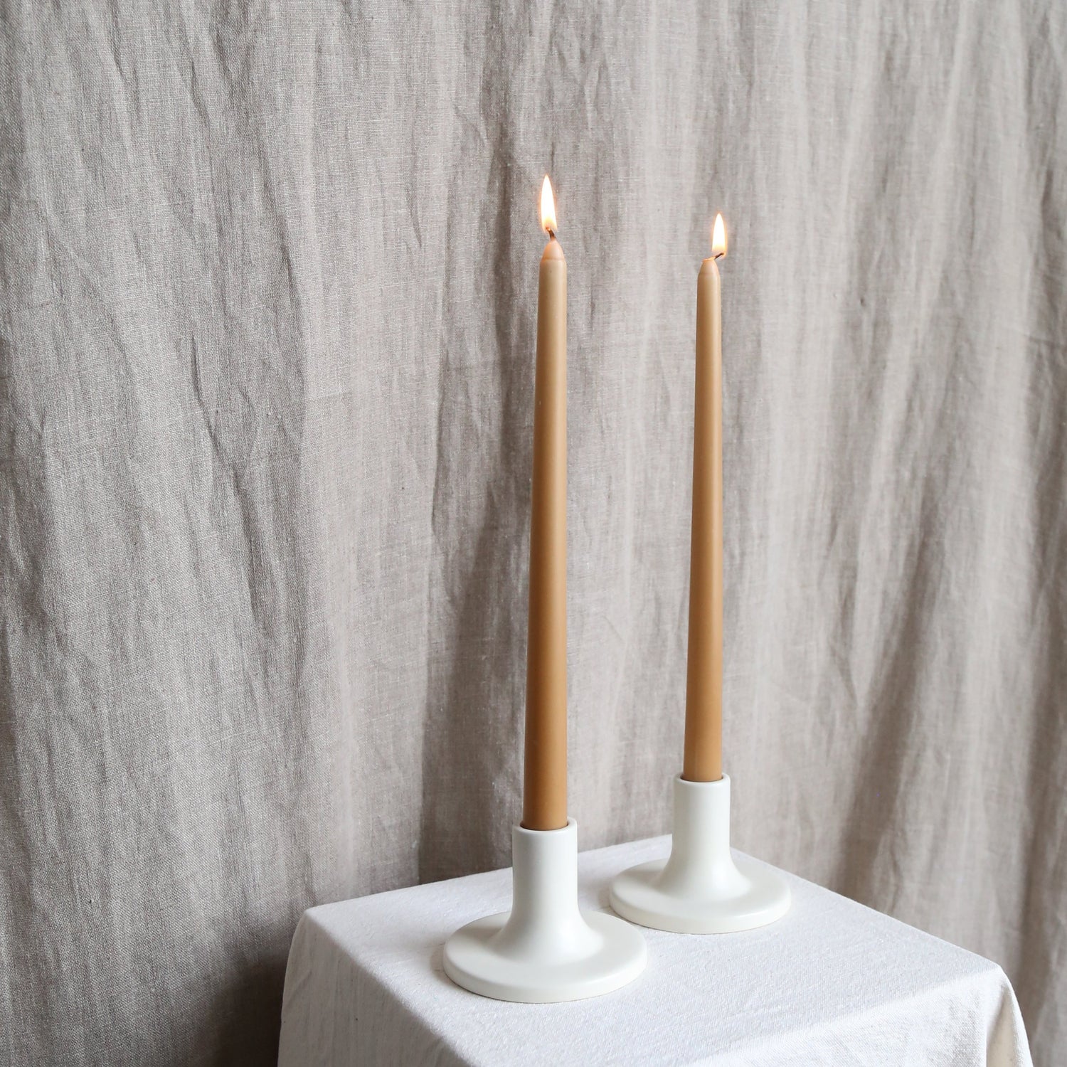 Pair of caramel taper candles in white holders available at Rook & Rose.