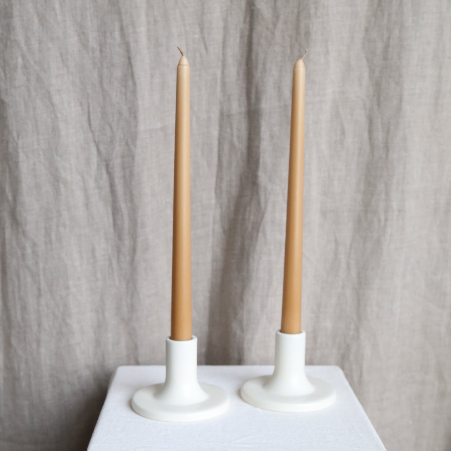 Pair of caramel taper candles in white holders available at Rook & Rose.