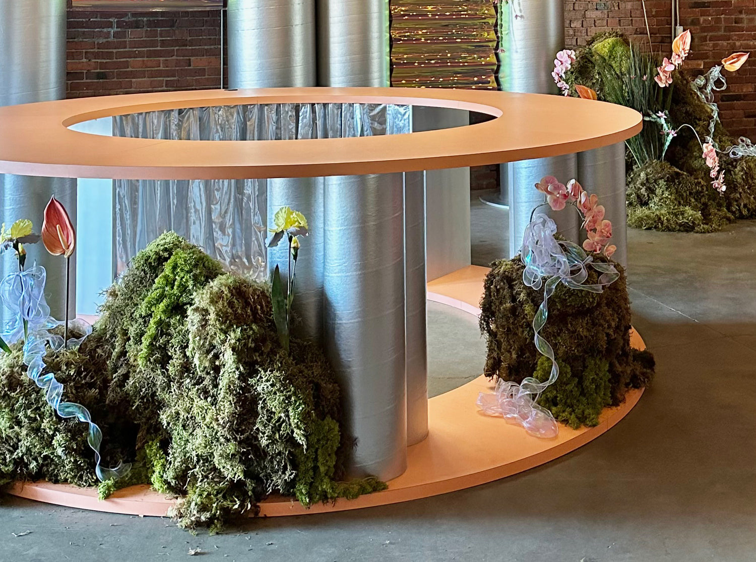 Sculptural moss and floral installation built around a circular bar by Rook & Rose