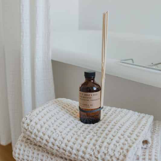 P.F Candle Co. Amber & Moss reed diffuser with rattan reeds available at Rook & Rose.
